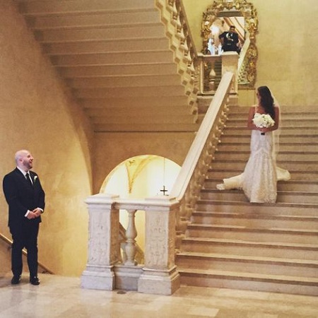 Melissa Wood walking down the stairs with a bouquet