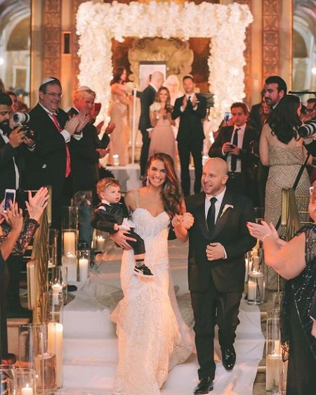 Noah Tepperberg is walking with wife Melissa Wood on their wedding day