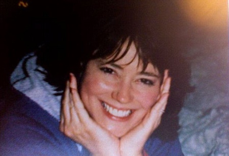 Melanie is posing for a picture with a smile