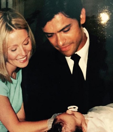 Mark and Ripa looking at their child