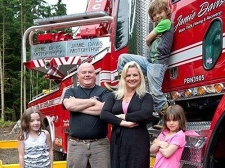 Adam Gazzola and Lucy Austin with their three children in front of a truck