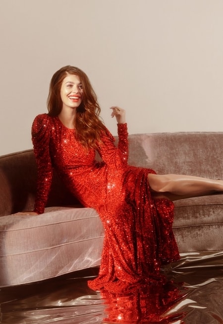 Camila Morrone posing in her red dress for the photoshoot