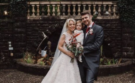  Bee Tucker and her husband at their wedding with their little daughter.