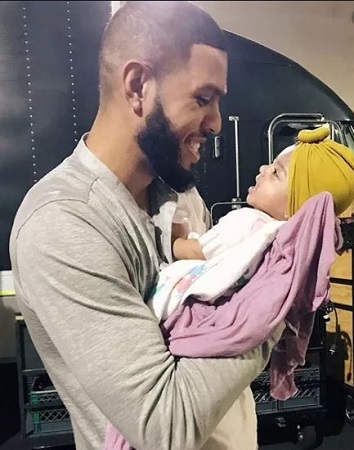 Image: Sarunas holding his daughter, Zen