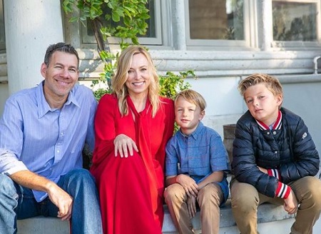 Jason with his wife and children picturing outside their home.