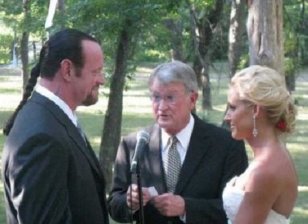 The Undertaker and Michelle McCool at their wedding day, exchanging rings and vows.