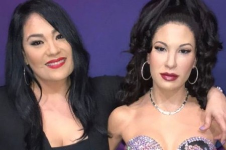 Suzette standing next to her late sister's wax statue.