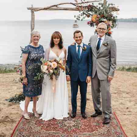 Emily Swallow and her husband, Chad Kimball standing alongside her parents. Explore more about the couple's married life.