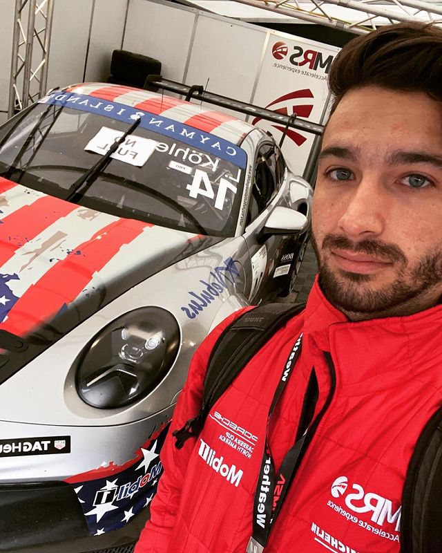 Gino Macauley wearing red jacket selfie  with grey modified porch racing car.