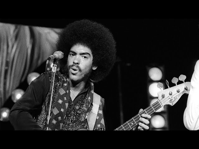 Black & white photo of Tommy DeBarge holding bass guitar.