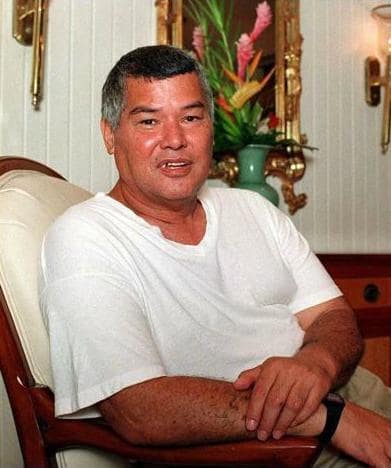 Portrait photo of Samuel Nowlin Reeves sitting in a chair wearing white t-shirt and black watch in his right hand rist.