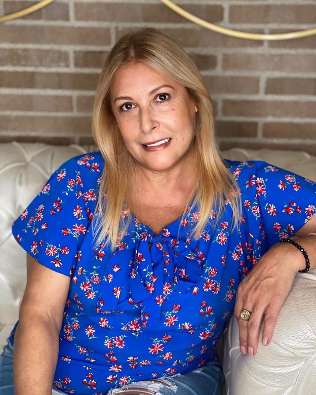 Photo of Ysabel Caminero Madera posing for insta post wearing a blue top and sitting on sofa