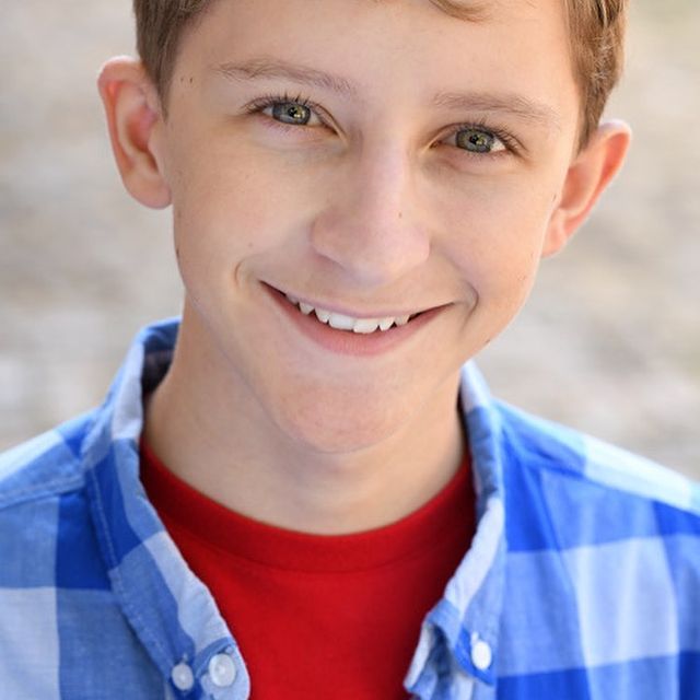 Photo of Owen Morgan wearing a red t-shirt and a blue check shirt.