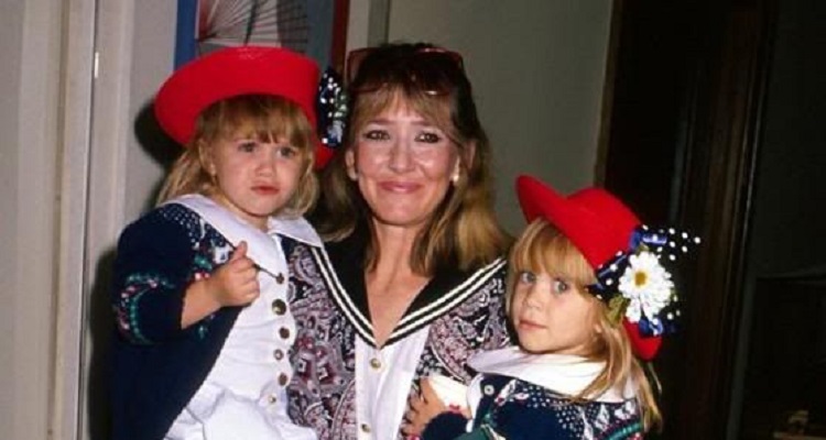 Jarnette Olsen carrying her two daughters