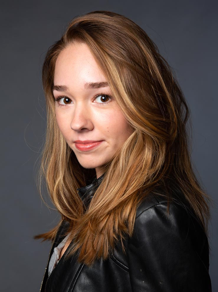 Holly Taylor posing for a photoshoot wearing black leather jacket