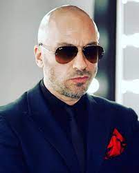 Dmitriy Nagiyev wearing a blue coat and a black spectacles.