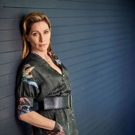Claudia Karvan posing by wearing mixed color green and blue dress with attached belt on it.