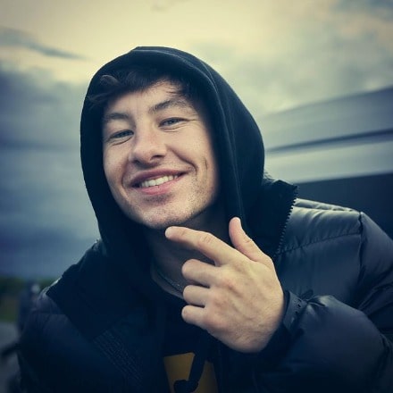 Barry Keoghan posing by wearing black hoodie and black jacket.