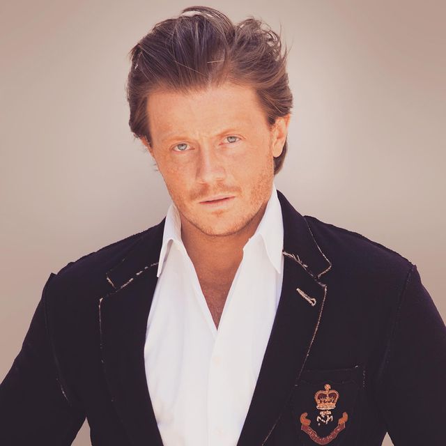 Photo of Zachary Garred wearing a black coat and a white shirt.