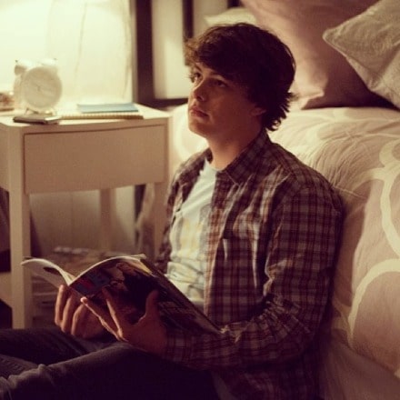 Israel Broussard posing by wearing white vest and black pant.