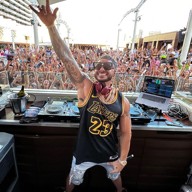 DJ Paul wearing black and yellow tang and blue half jeans.