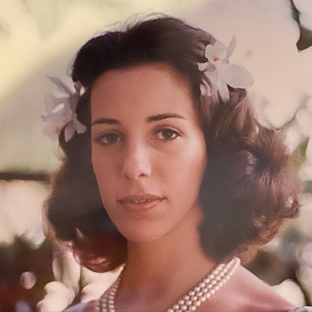 Elena Saurel posing by wearing white gown.