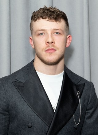 Kevin Csolak wearing black coat and white shirt