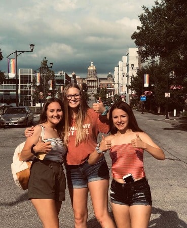 Ysabel Brown posing with her sisters by wearing orange t-shirt and blue hot pant.