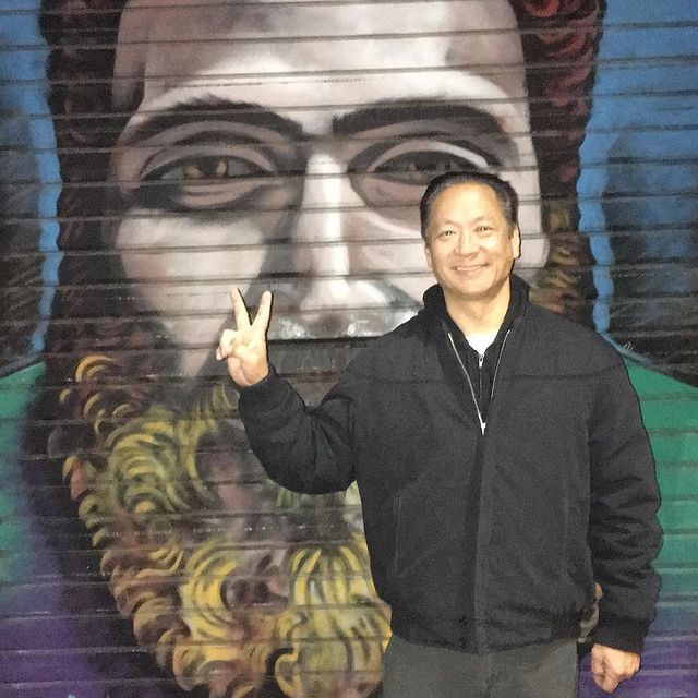 Jeff is wearing black coat with light grey pant.