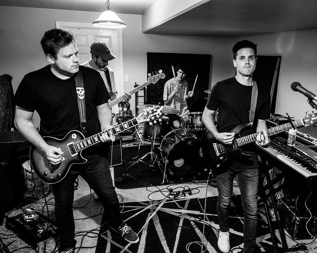 Christopher and his left side friend is wearing black pants and t-shirt.