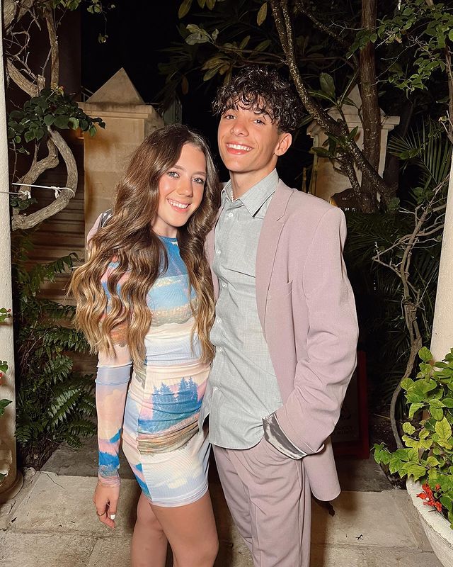 She is wearing one piece and her boyfriend is wearing coat.