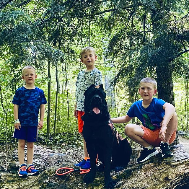 three sons are wearing blue t-shirt and half pants.