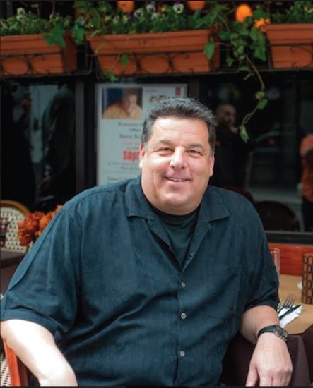 Steve Schirripa posing for photo wearing black shirt