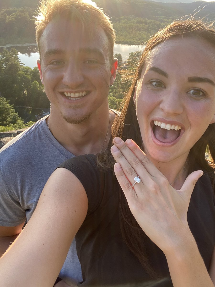 Sydney Golic with her husband Ben Braunecker taking selfie showing engagement ring in her left hand with a excitement