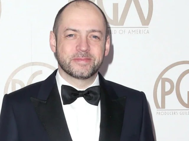 Gareth Neame  was captured wearing black coat white shirt and black tie