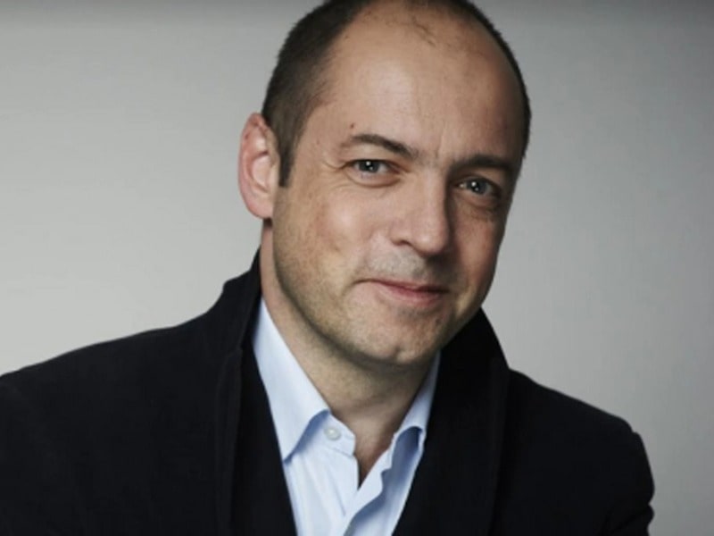 Gareth Neame  was captured wearing black jacket  and white shirt 