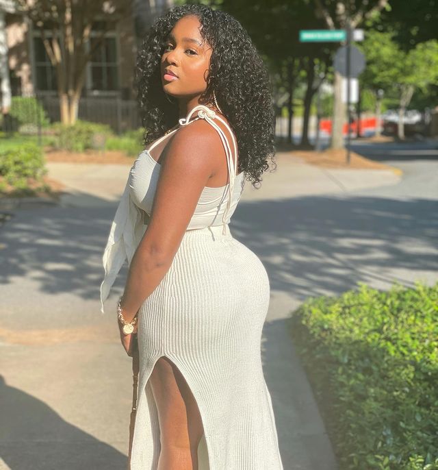 Ayana posing for a photoshoot wearing white dress