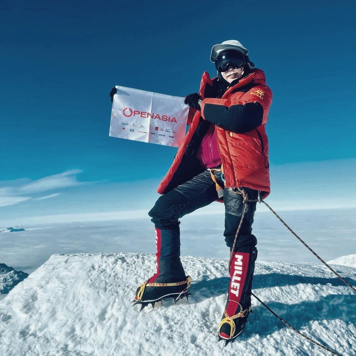 Céline Nha Nguyen posing in the peak of the Mount Everest  showing the Flag writing OPEANASIA in it.