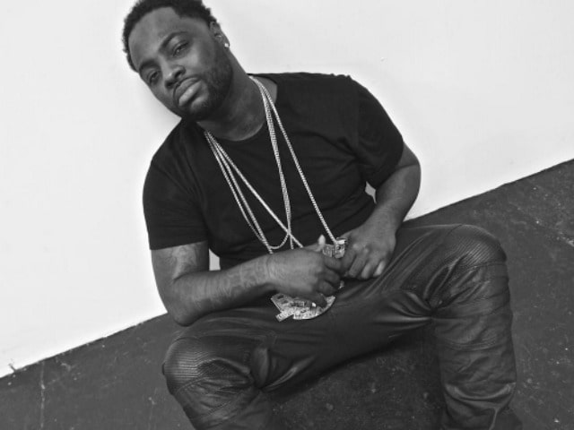 Wooh da kid posing for the photo by sitting wearing more than 3,four lockets