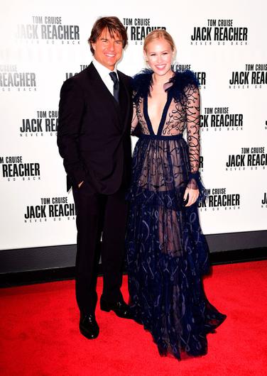 Danika Yarosh posing for the photo with her co star of the movie Tom Cruise a dark grey hair and a big laughter in her face.