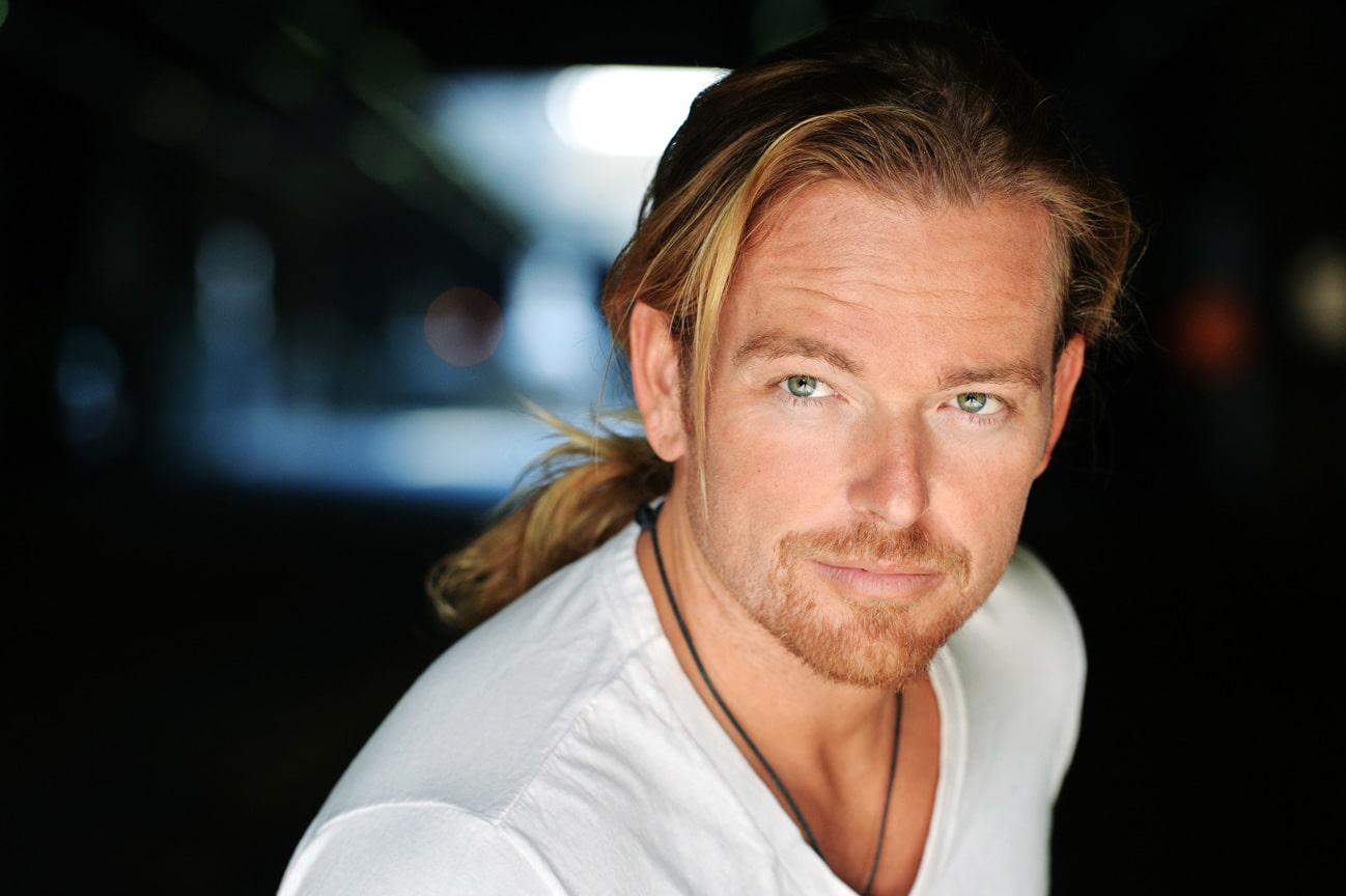 Jonathan Scarfe wearing white t-shirt with a long hair 