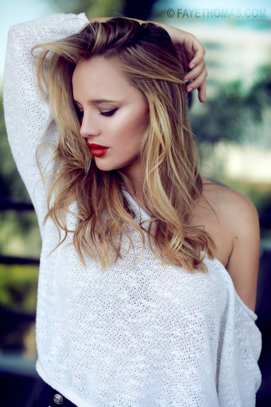 Natasha Loring in a short grey brown hair wearing white tshirt and her one hand in her hair