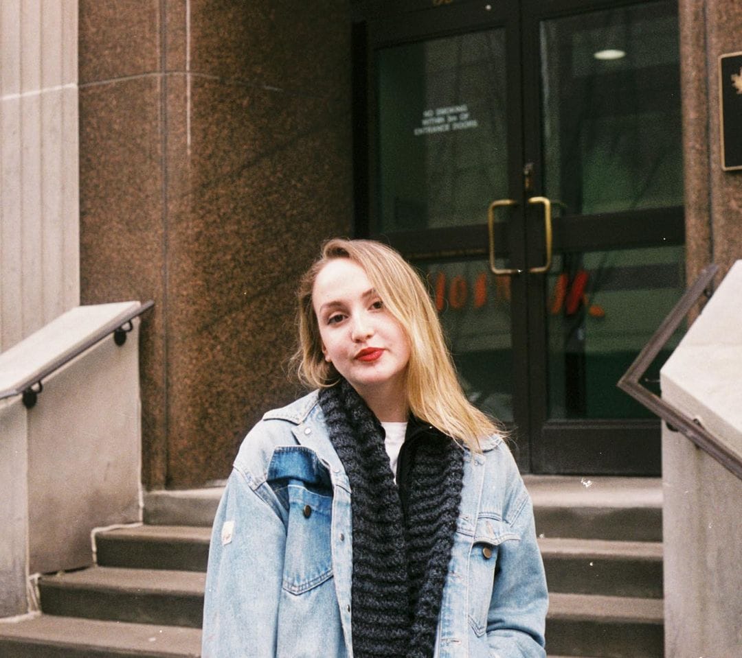 Ella Jonas Farlinger posing for a photo in a beautiful look wearing jeans jacket and black muffler