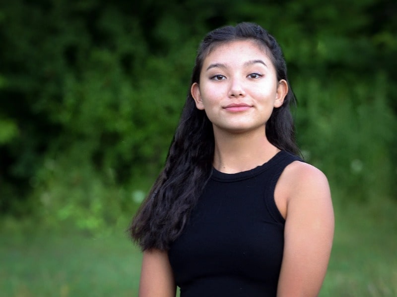 Kiawentiio Tarbell posing for photo wearing black t-shirt with a black hair