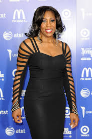 Dawnn Lewis wearing black body cone  with a long ear ring and short black hair