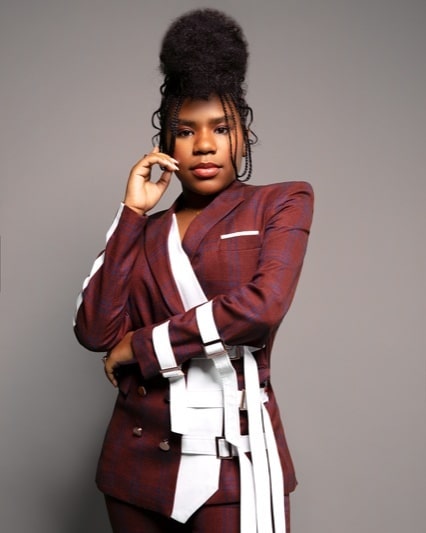 Trinitee Stokes wearing black and white dress and tying her hair in upside of head