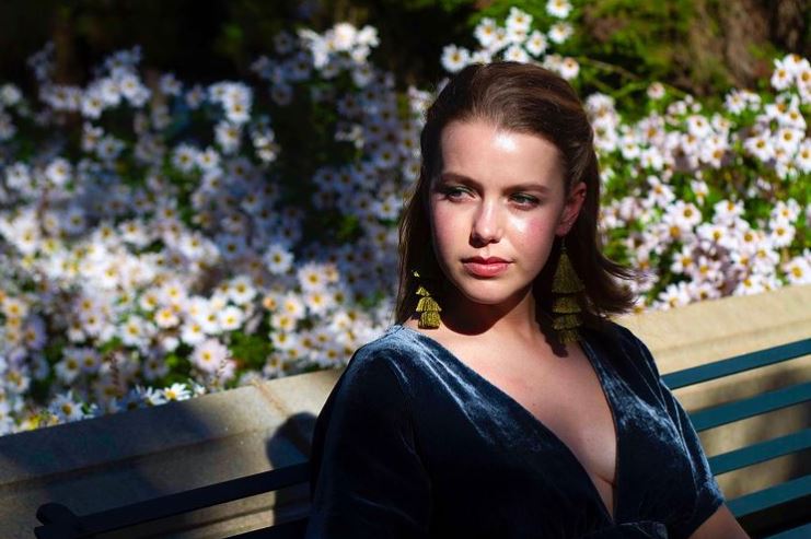 Devon Hales was captured looking at the right side wearing blue gown and short brown hair