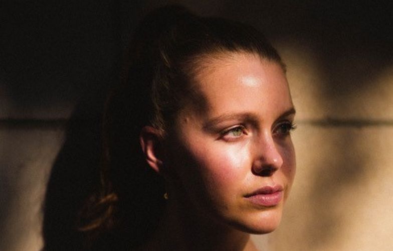 Devon Hales was captured looking at the left side with tying her short brown hair