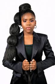 Trinitee Stokes wearing black dress and tying her hair in different parts