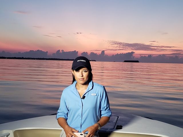 Picture of Kaylee Hartung posing for a photoshoot wearing blue shirt and black color cap